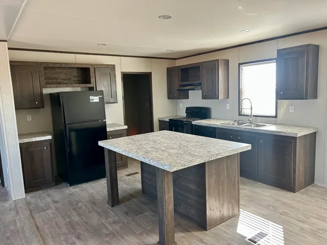 a kitchen with stainless steel appliances granite countertop a sink a refrigerator and a stove