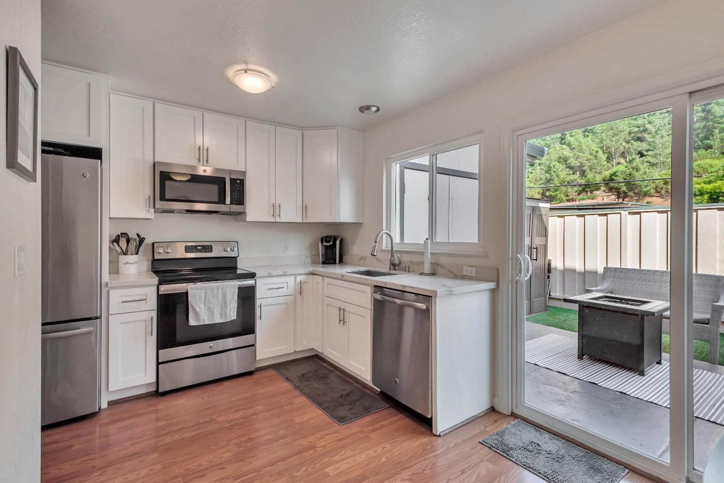 1377 Lerida Way Pacifica, CA 94044 - Photo 8 of 25 a kitchen with granite countertop a refrigerator stove and microwave