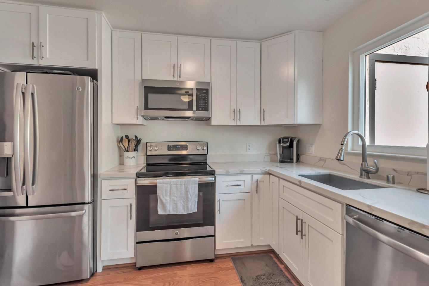 1377 Lerida Way Pacifica, CA 94044 - Photo 9 of 25 a kitchen with white cabinets and stainless steel appliances