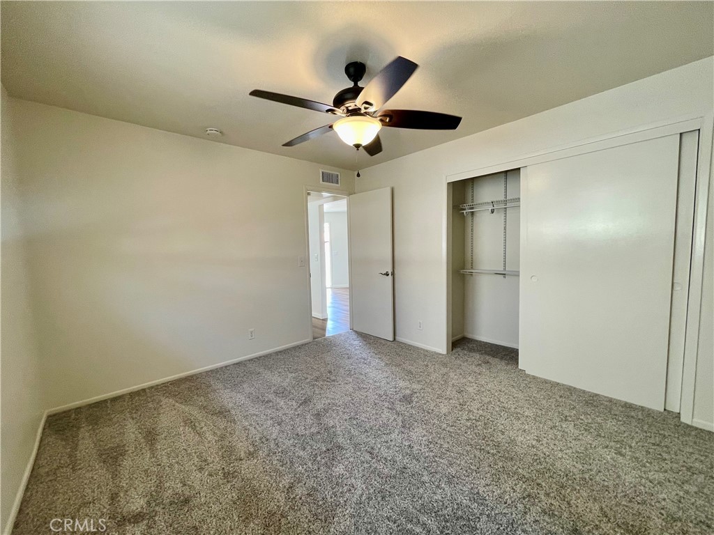 258 Avenida Victoria, Unit D San Clemente, CA 92672 - Photo 7 of 12 an empty room with closet and a chandelier fan