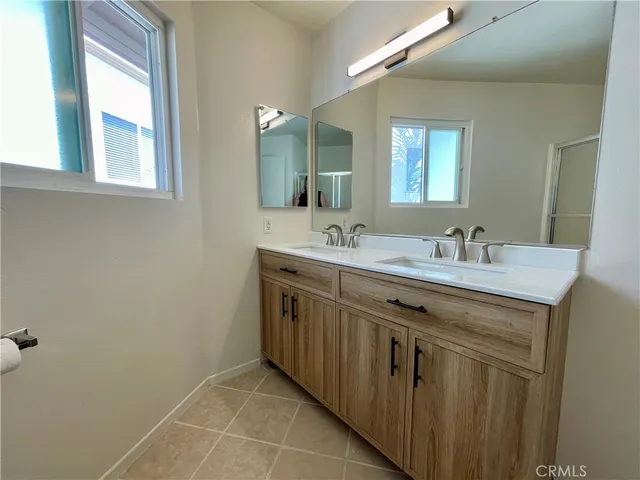 a bathroom with a double vanity sink and a mirror