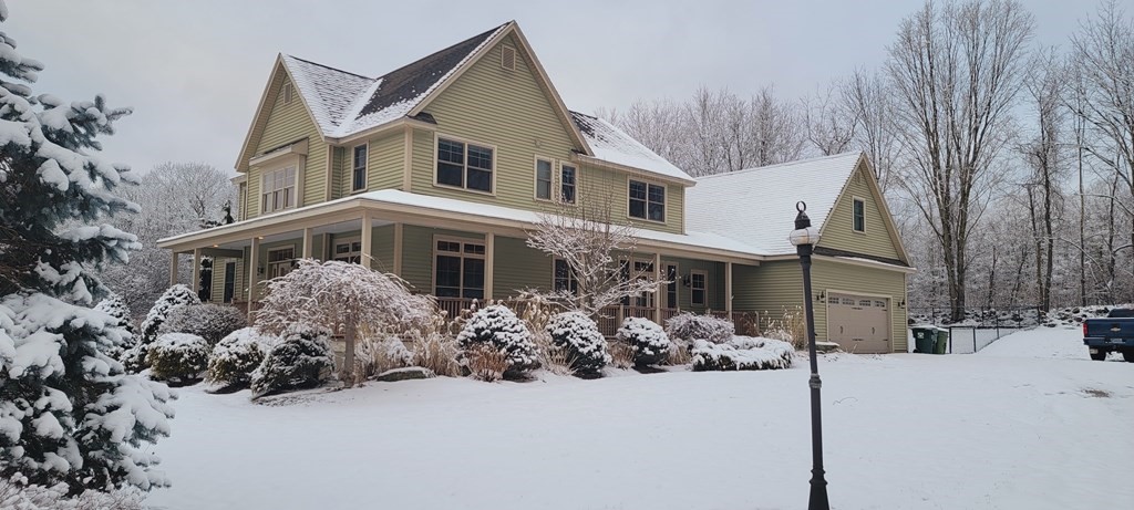 358 Rutherford Road Oakham, MA 01068 - Photo 2 of 42 a front view of a house with a yard covered in snow
