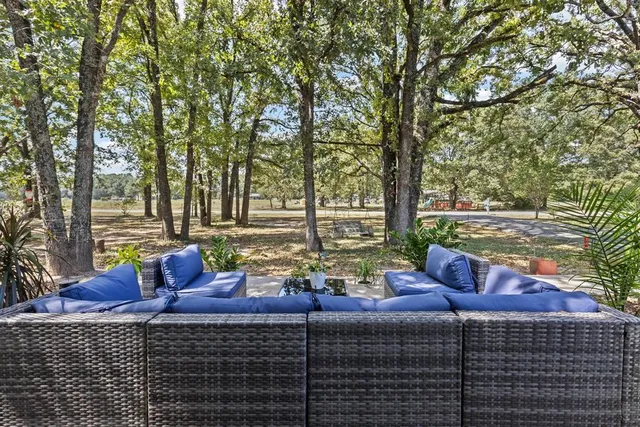 a view of a patio with table and chairs and wooden fence