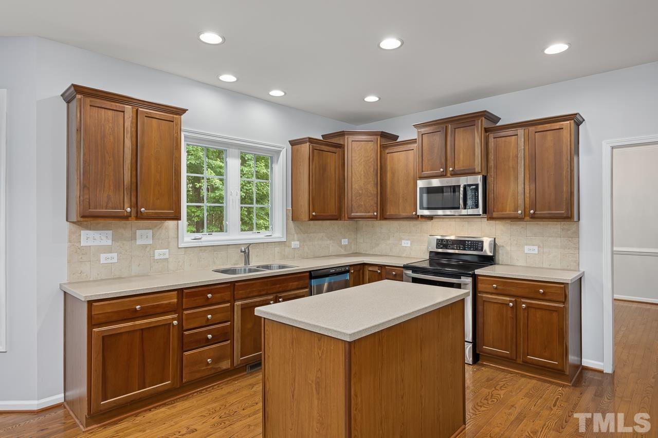 4506 Paces Ferry Drive Durham, NC 27712 - Photo 11 of 38 a kitchen with stainless steel appliances granite countertop a stove top oven a sink dishwasher a refrigerator and cabinets with wooden floor