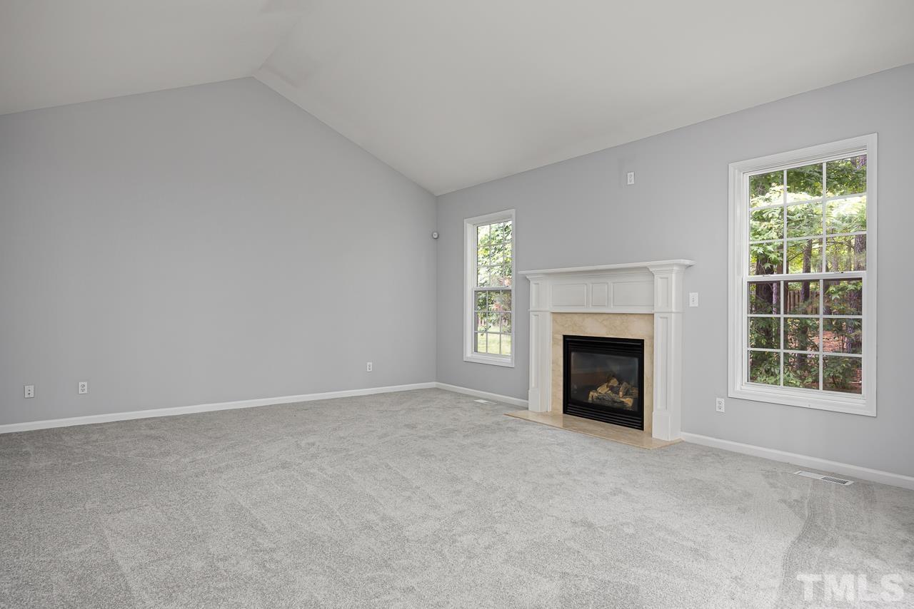 4506 Paces Ferry Drive Durham, NC 27712 - Photo 15 of 38 an empty room with a fireplace and windows