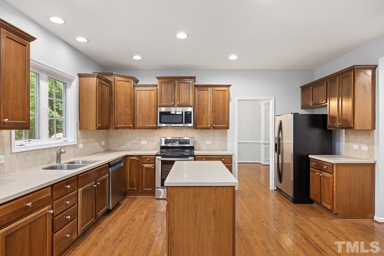 4506 Paces Ferry Drive Durham, NC 27712 - Photo 10 of 38 a kitchen with stainless steel appliances granite countertop sink stove refrigerator and cabinets
