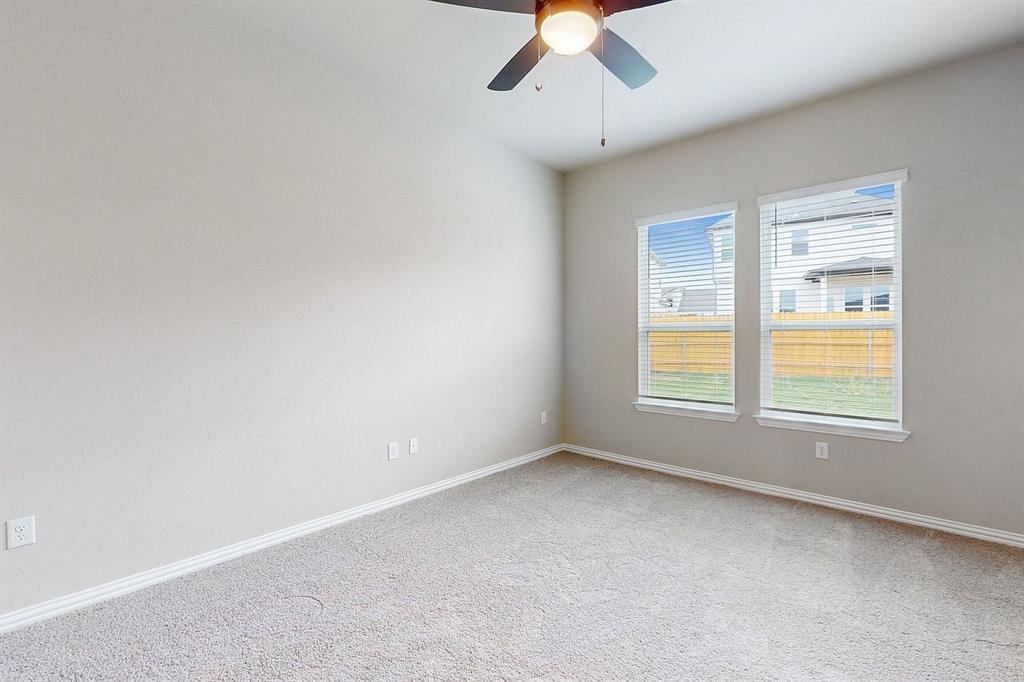 4907 Escape Rivera Drive Austin, TX 78747 - Photo 9 of 28 A quiet retreat, this bedroom offers soft carpeted floors and a cooling ceiling fan for ultimate comfort.