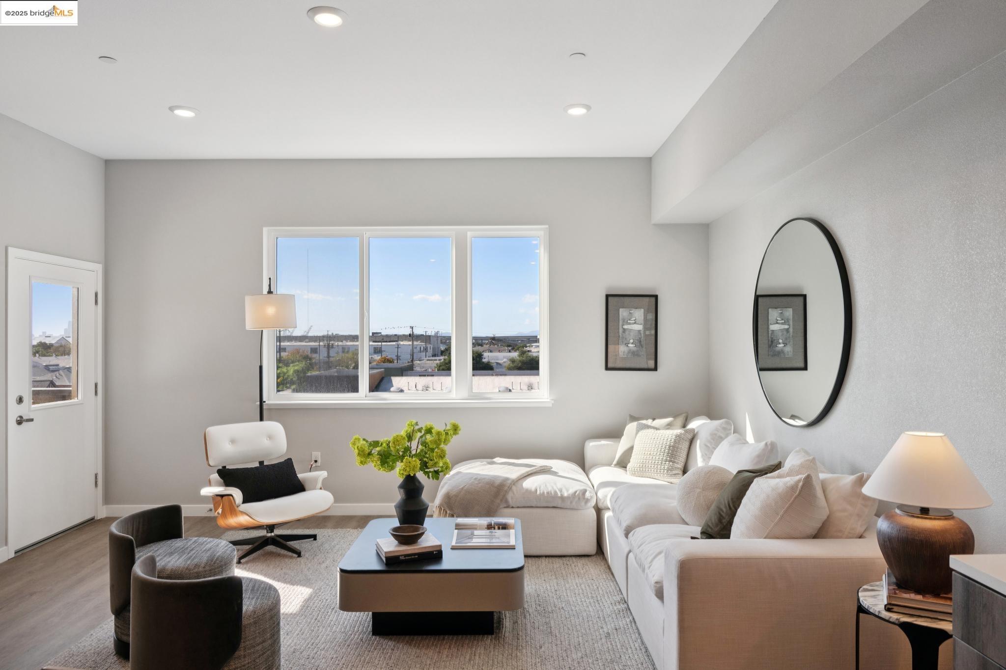 2400 Adeline Street, Unit 403 Oakland, CA 94607 - Photo 3 of 25 a living room with furniture a lamp a rug and a large window