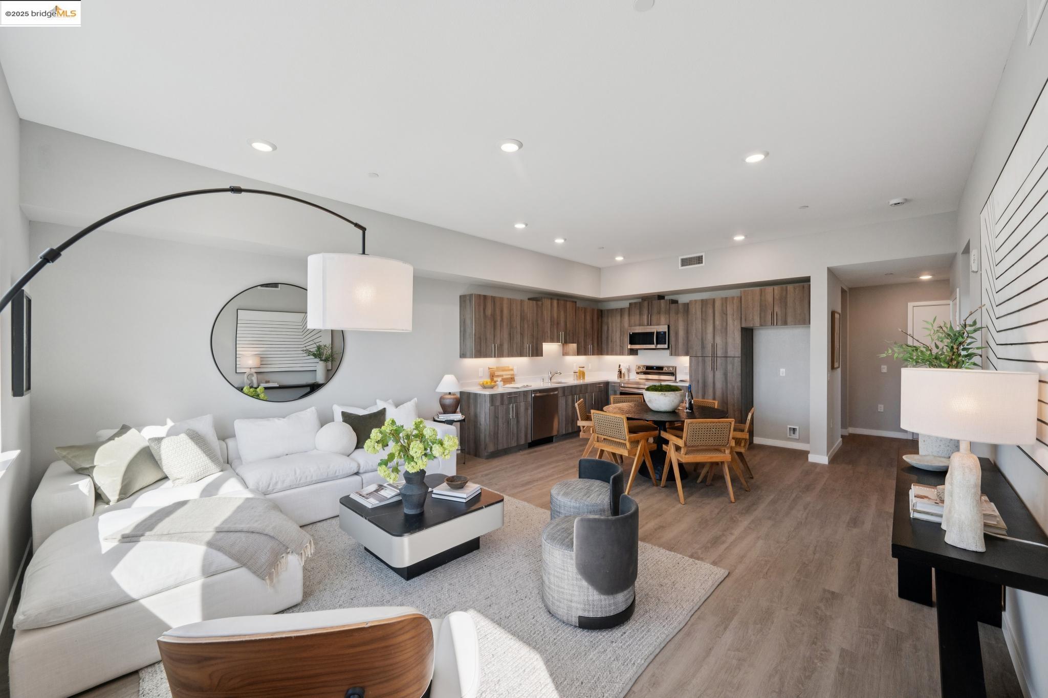 2400 Adeline Street, Unit 403 Oakland, CA 94607 - Photo 4 of 25 a living room with furniture kitchen view and a wooden floor