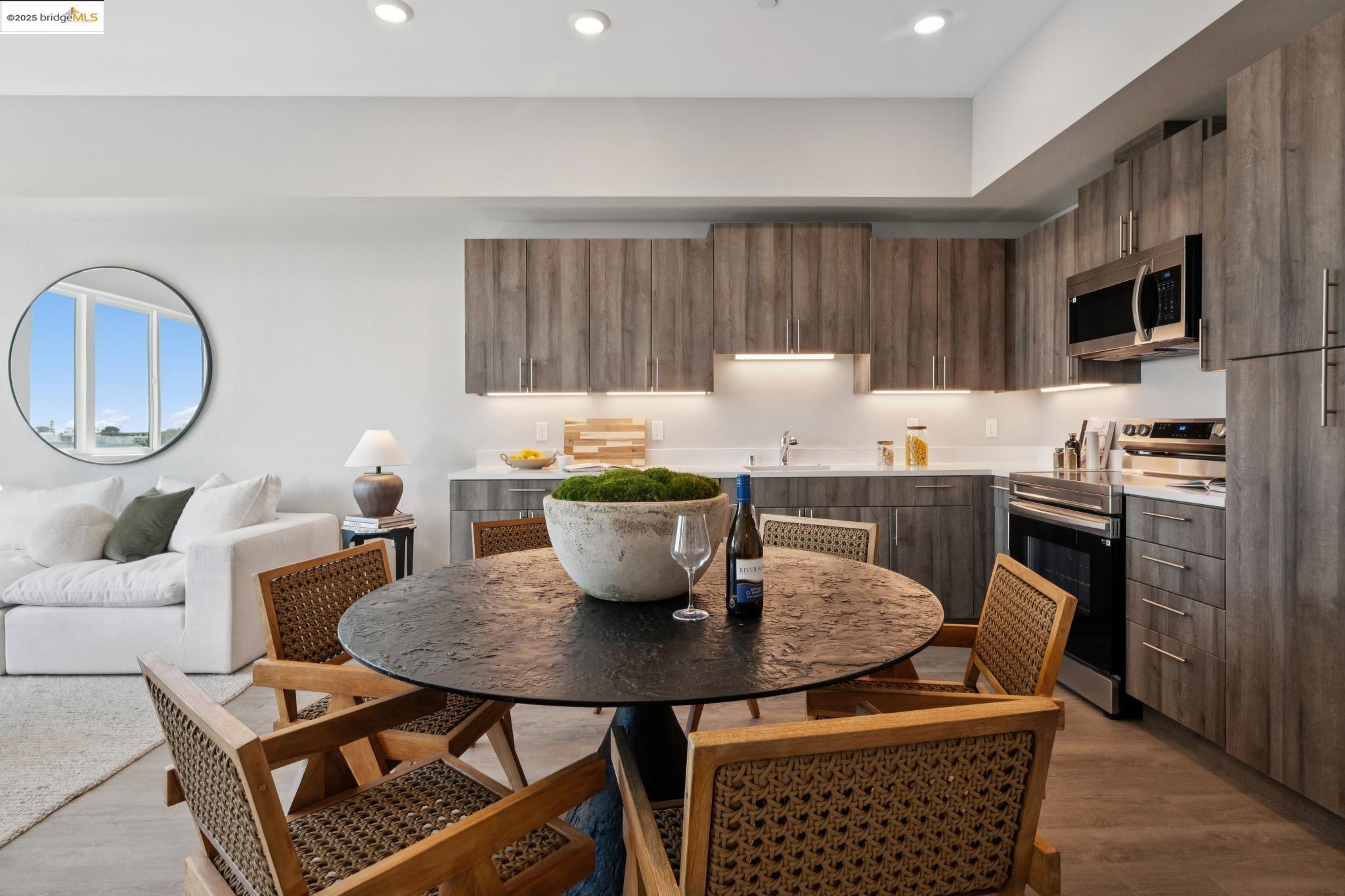 2400 Adeline Street, Unit 403 Oakland, CA 94607 - Photo 8 of 25 a kitchen with a table chairs and a refrigerator