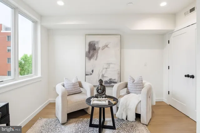 a living room with furniture and a painting on the wall