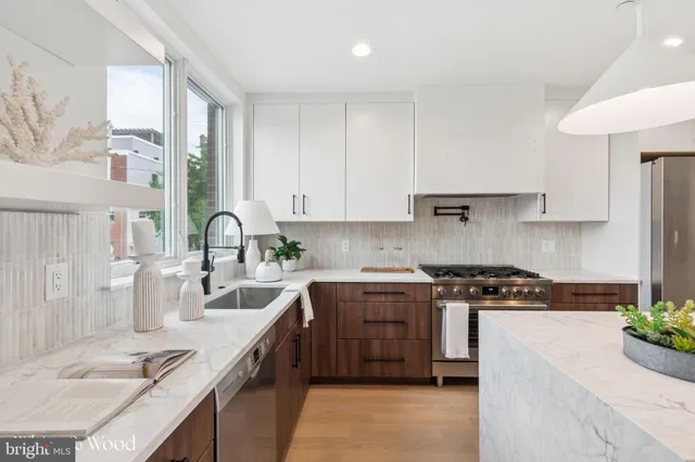 a kitchen with a sink a stove and wooden cabinets