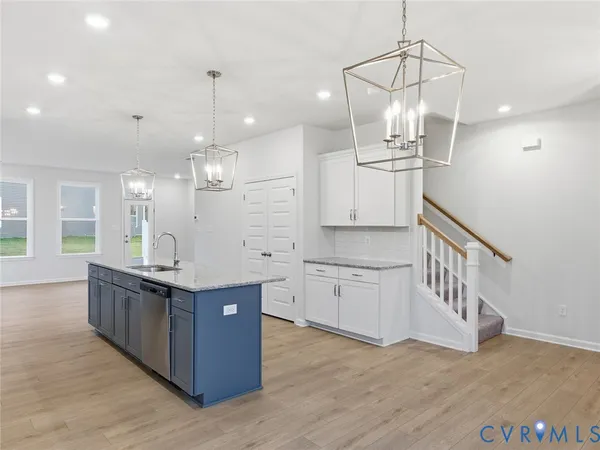 a kitchen with stainless steel appliances granite countertop a sink and cabinets with wooden floor