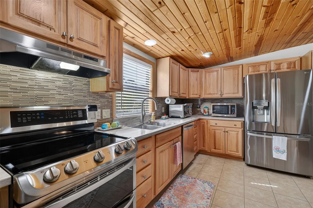 3567 Manatee Road Tavares, FL 32778 - Photo 12 of 67 a kitchen with stainless steel appliances granite countertop a refrigerator a stove and a sink