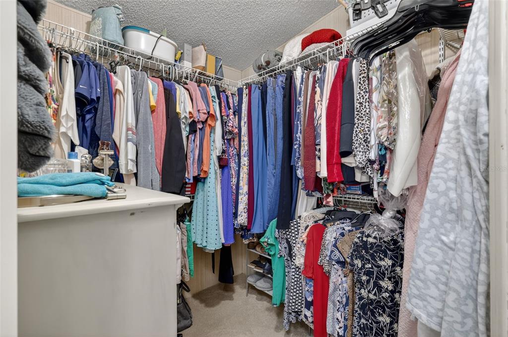 3567 Manatee Road Tavares, FL 32778 - Photo 21 of 45 a view of walk in closet with clothes and shoes