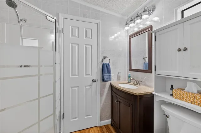 a bathroom with a sink vanity and shower