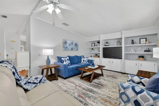 a living room with furniture a flat screen tv and a window