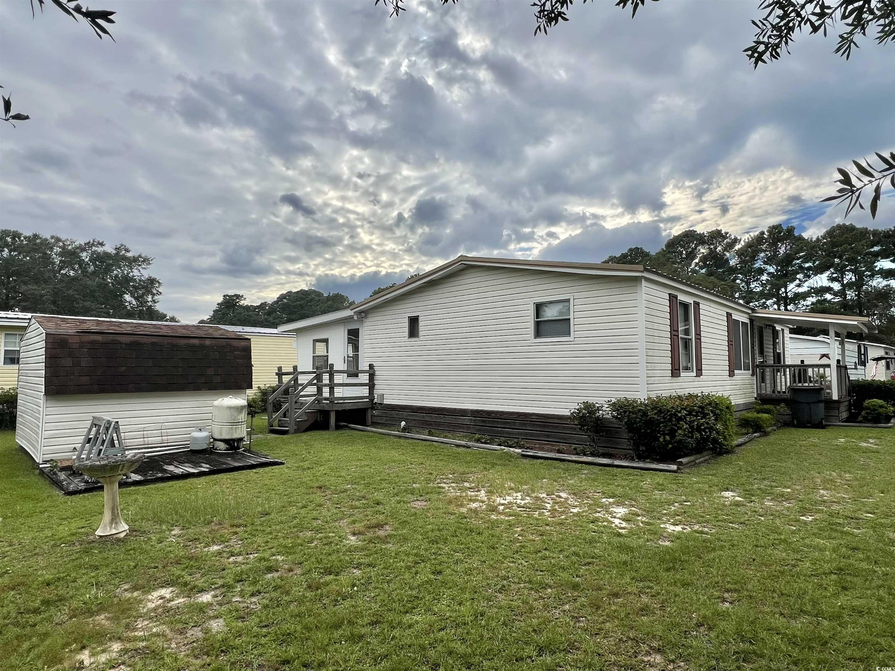 54 Crooked Island Circle Murrells Inlet, SC 29576 - Photo 14 of 37 View of side of home featuring a yard and a storage unit
