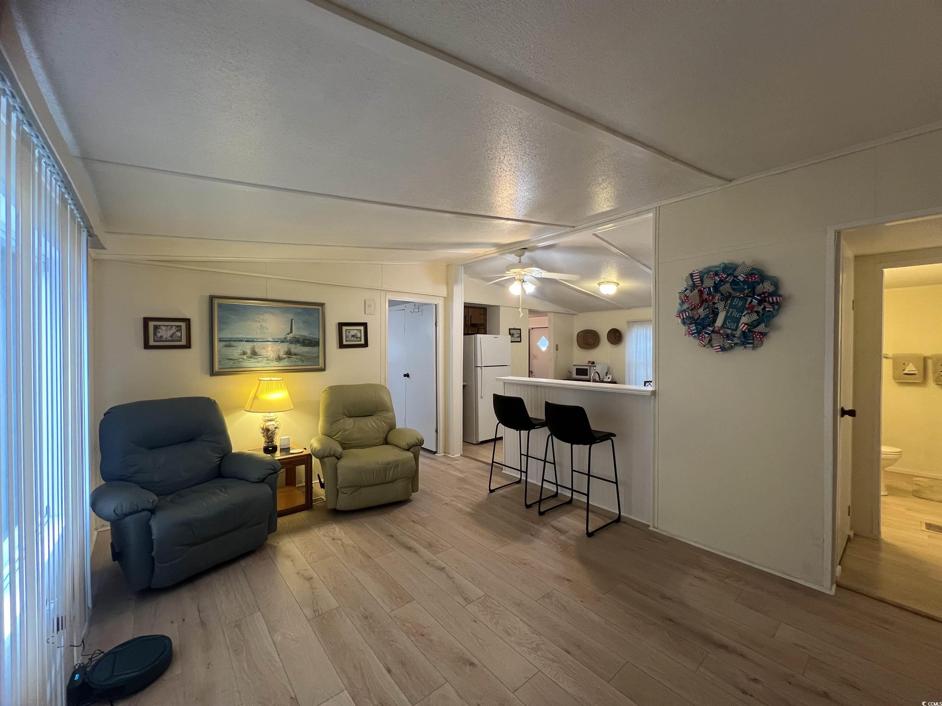 54 Crooked Island Circle Murrells Inlet, SC 29576 - Photo 22 of 37 Kitchen featuring white appliances, light wood finished floors, vaulted ceiling, tasteful backsplash, and white cabinets