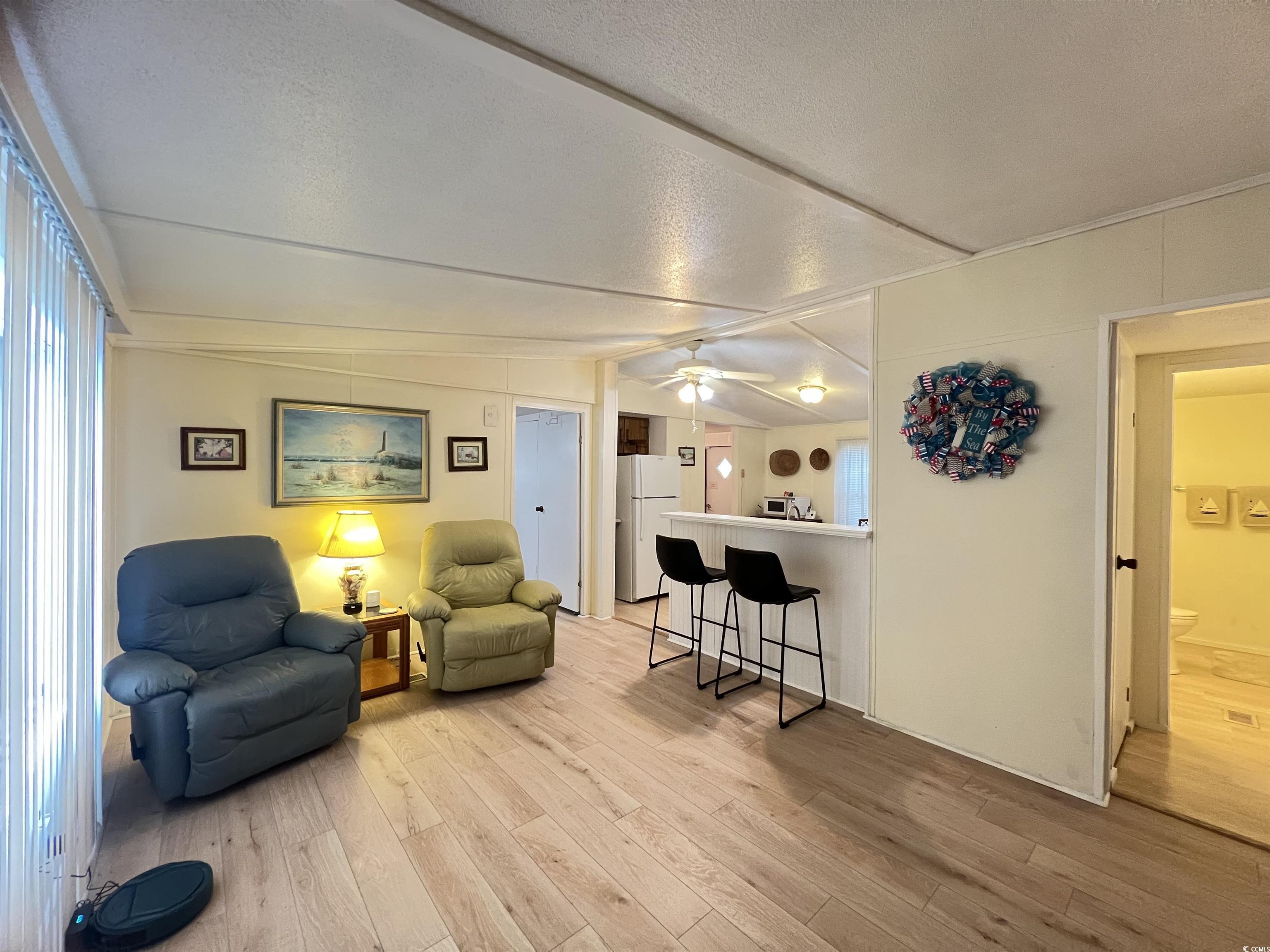 54 Crooked Island Circle Murrells Inlet, SC 29576 - Photo 23 of 37 Living room featuring light wood-type flooring, lofted ceiling, ceiling fan, and a textured ceiling