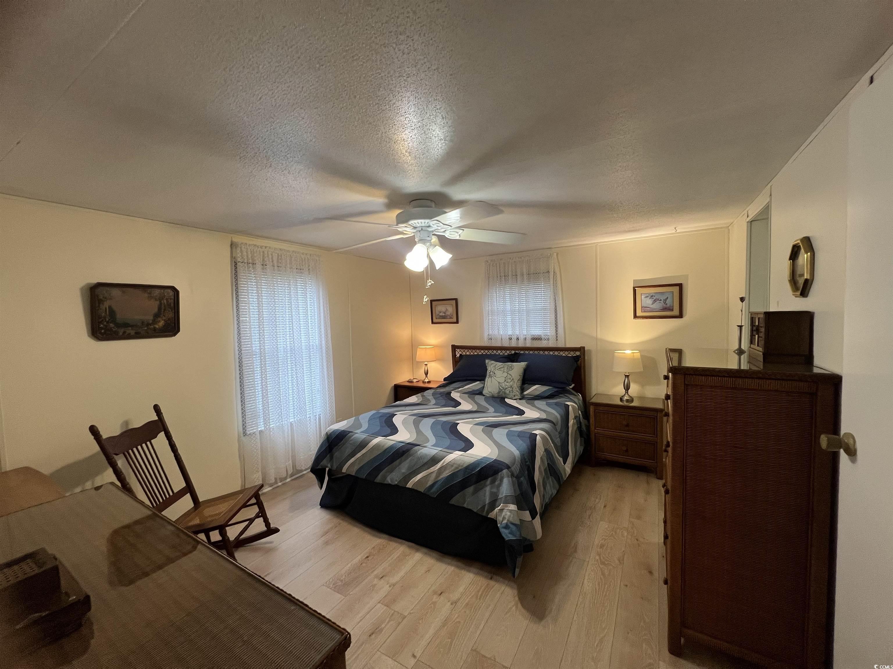 54 Crooked Island Circle Murrells Inlet, SC 29576 - Photo 25 of 37 Living area featuring light wood-type flooring, healthy amount of natural light, a stone fireplace, and vaulted ceiling