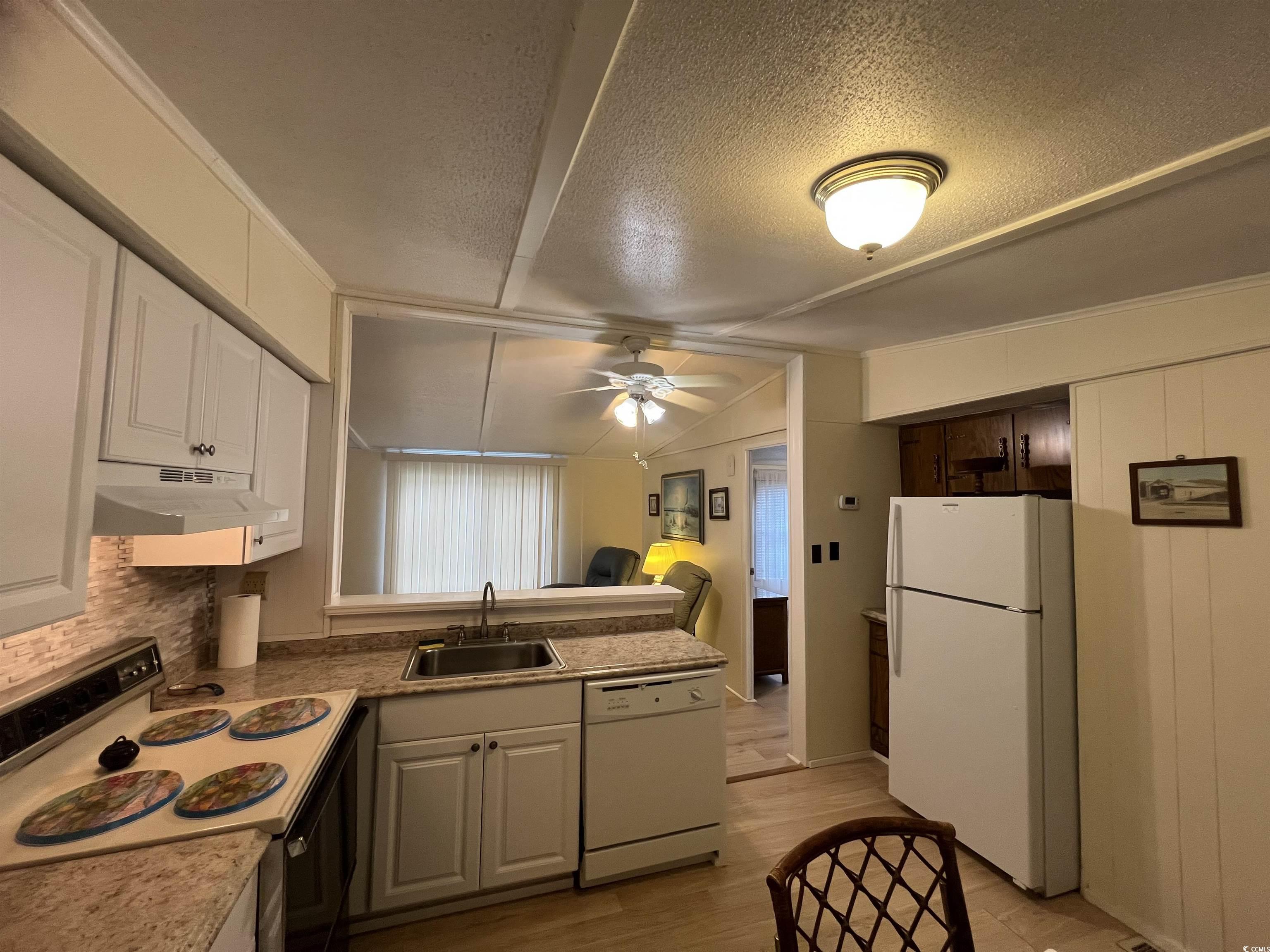 54 Crooked Island Circle Murrells Inlet, SC 29576 - Photo 30 of 37 Kitchen featuring electric stove, light wood-type flooring, white cabinets, a textured ceiling, and lofted ceiling