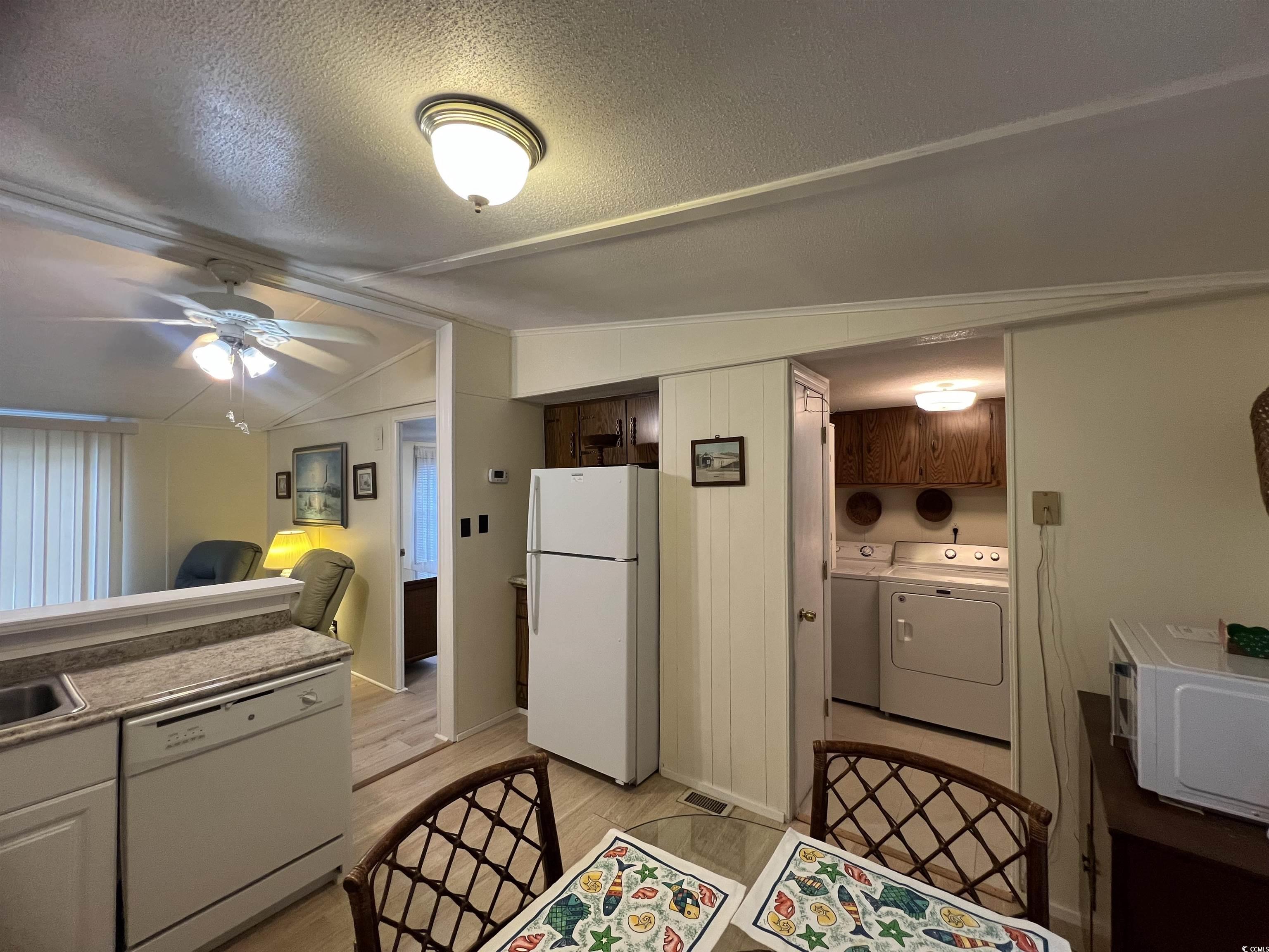 54 Crooked Island Circle Murrells Inlet, SC 29576 - Photo 31 of 37 Kitchen featuring white appliances, a peninsula, light wood-style floors, vaulted ceiling, and ceiling fan