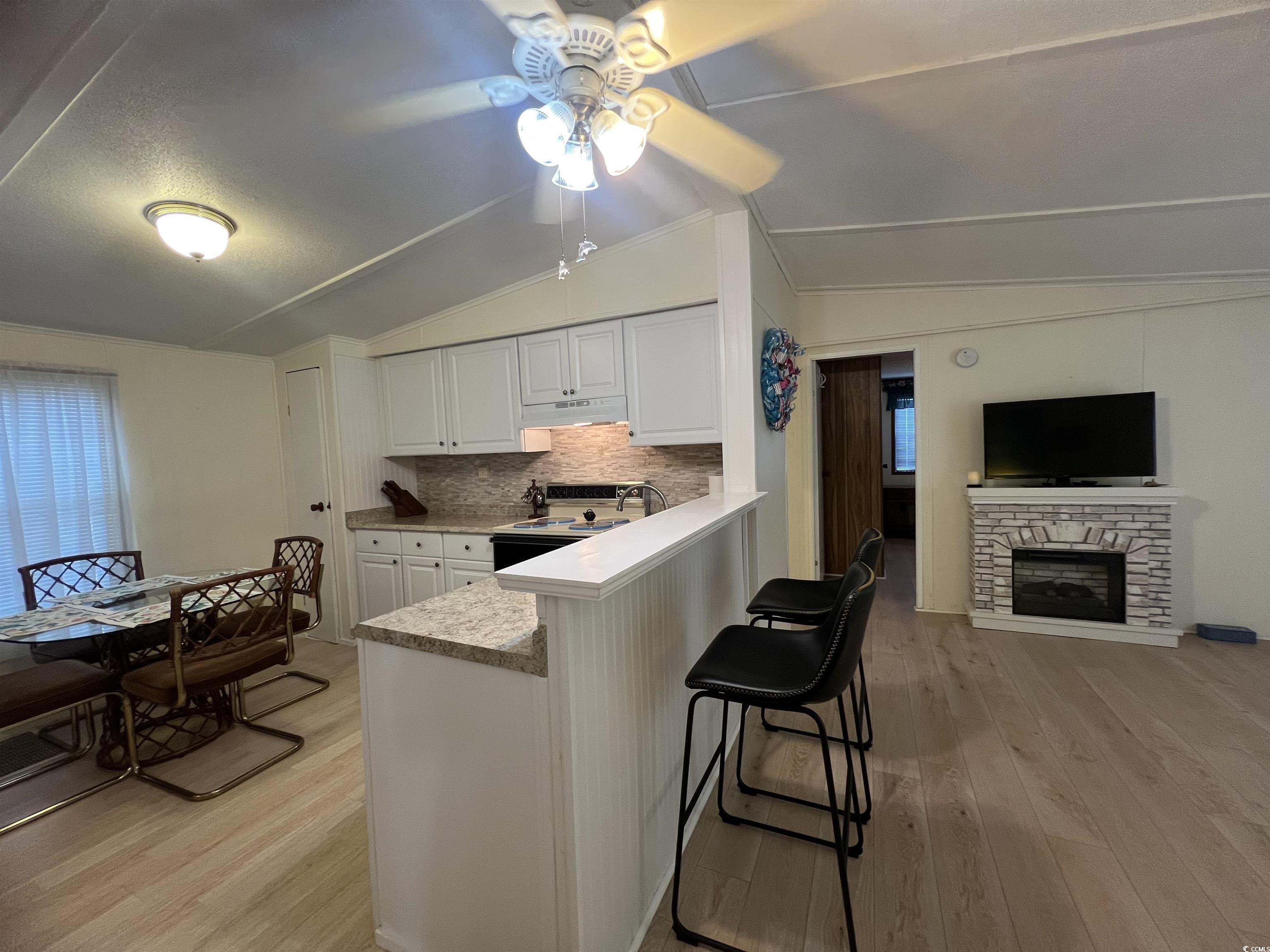 54 Crooked Island Circle Murrells Inlet, SC 29576 - Photo 32 of 37 Kitchen with white appliances, light wood-type flooring, ceiling fan, a textured ceiling, and vaulted ceiling