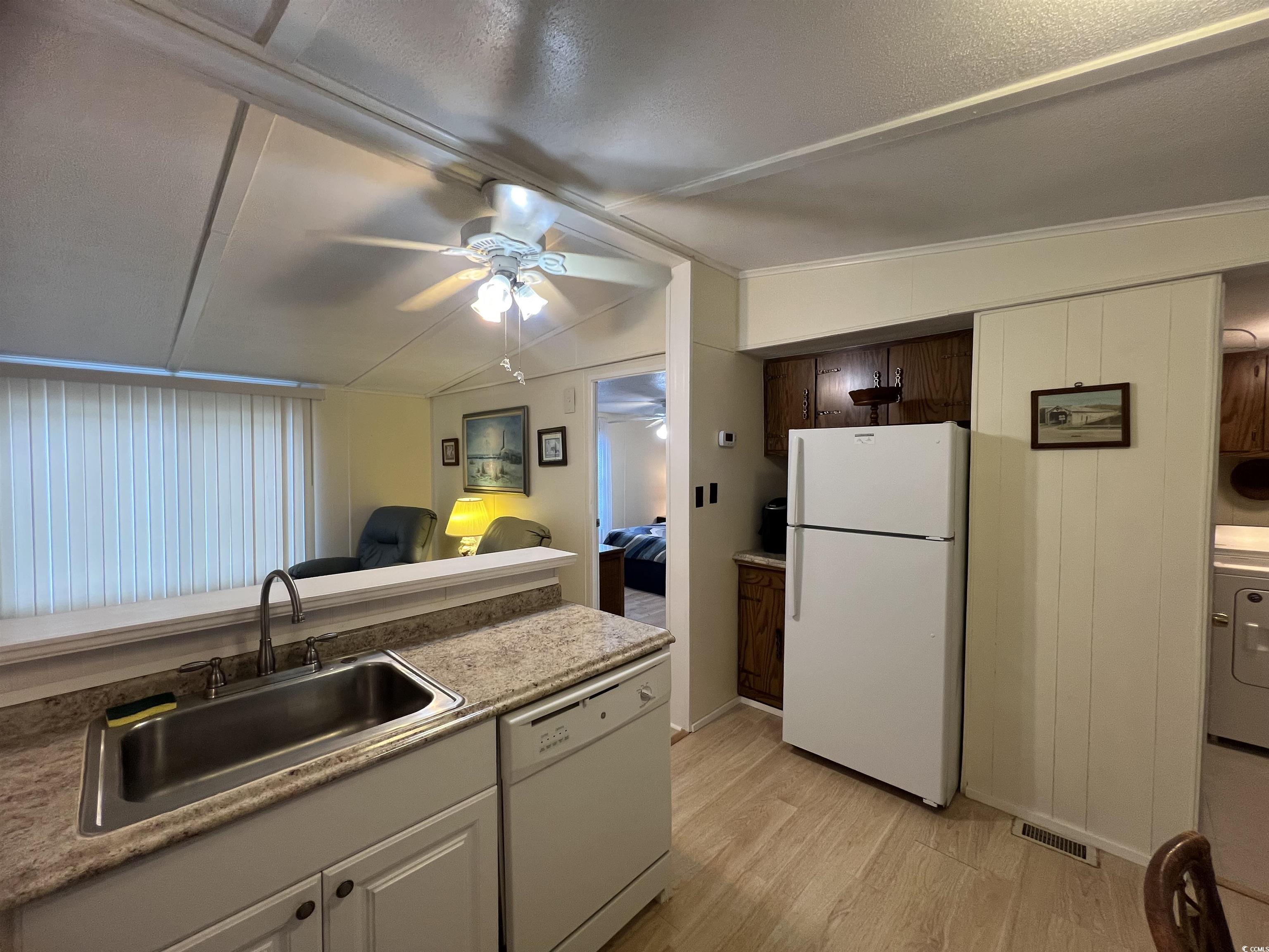 54 Crooked Island Circle Murrells Inlet, SC 29576 - Photo 33 of 37 Kitchen with light wood-style flooring, backsplash, lofted ceiling, white electric stove, and white cabinets