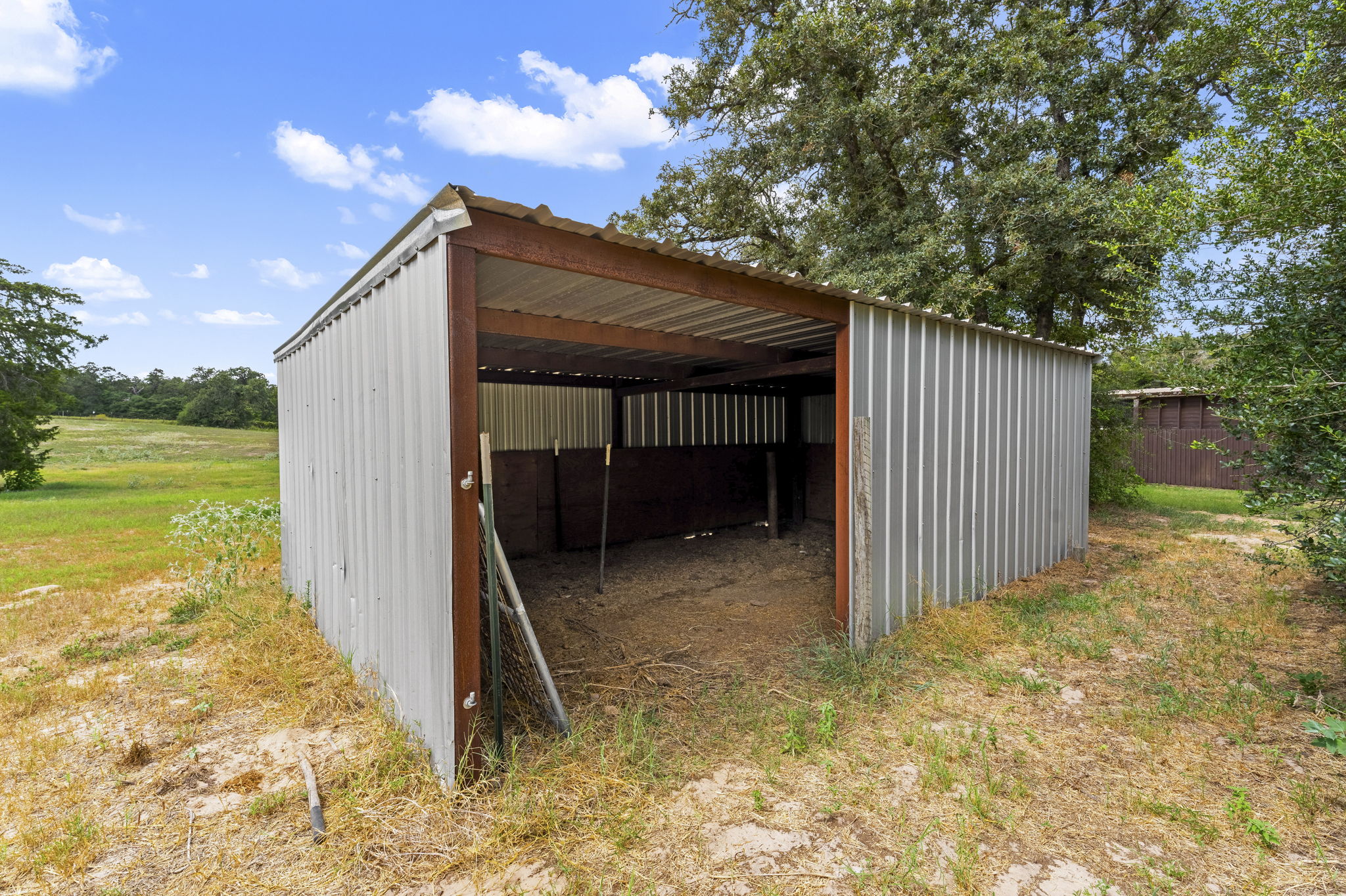 206 22 Hills Road Gause, TX 77857 - Photo 14 of 28 A durable metal outbuilding provides functional outdoor storage on this scenic rural acreage.