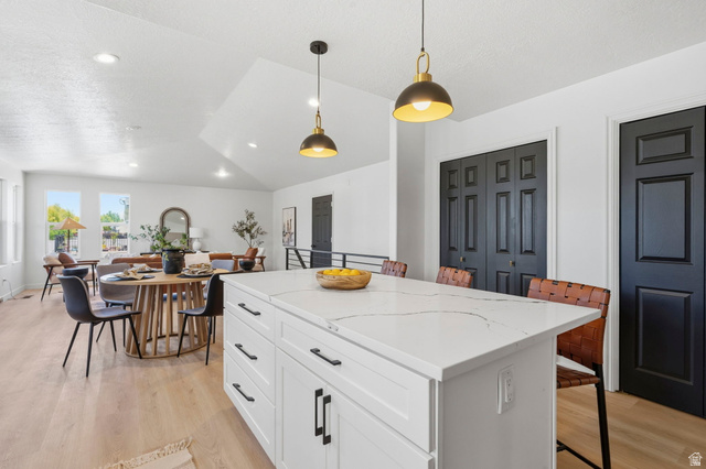 2460 Allison Way Syracuse, UT 84075 - Photo 8 of 24 Kitchen island featuring a white countertop with subtle veining, shaker-style cabinetry, and matte black hardware