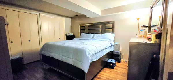 a bedroom with a bed and wooden floor