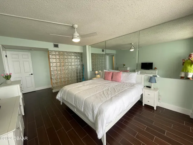 a bathroom with a granite countertop toilet a sink and a large mirror