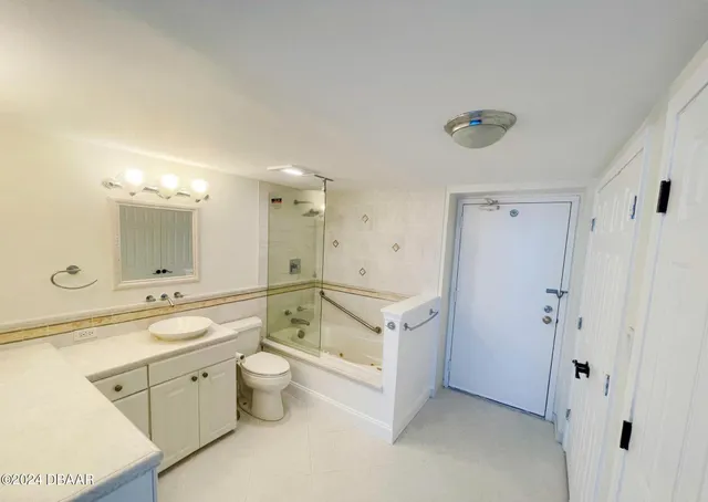 a bedroom with a bed painting on the wall and a large window