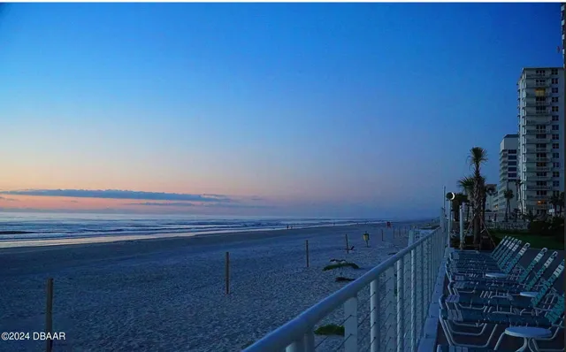 a kitchen that has a lot of cabinets a sink and wooden floor
