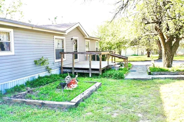 a front view of a house with a yard and potted plants