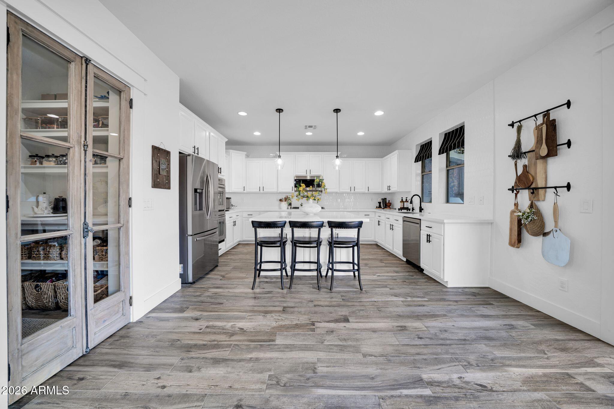 2985 North Point Ridge Road Buckeye, AZ 85396 - Photo 39 of 107 a kitchen with stainless steel appliances kitchen island granite countertop a refrigerator and a stove top oven