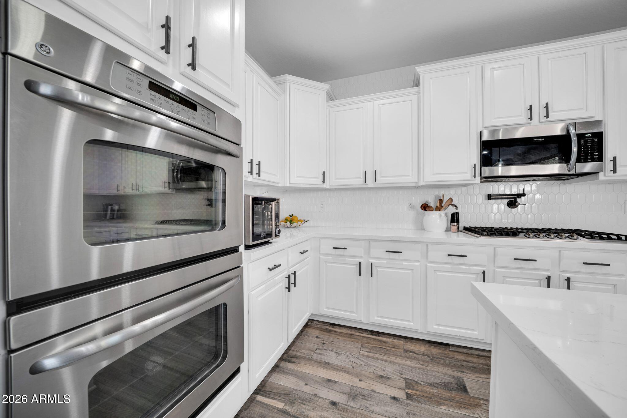2985 North Point Ridge Road Buckeye, AZ 85396 - Photo 51 of 107 a kitchen with granite countertop white cabinets white stainless steel appliances and white cabinets