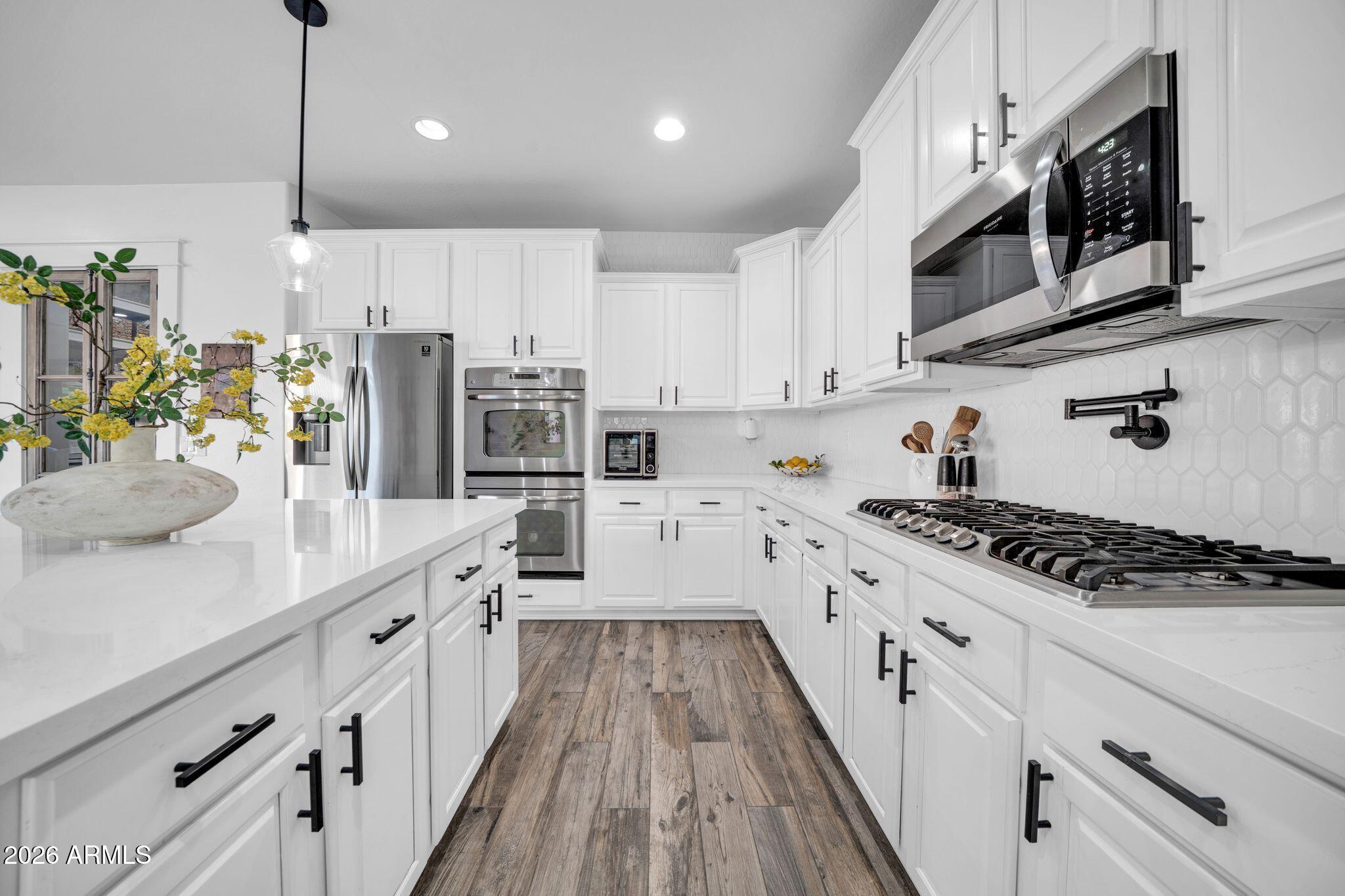 2985 North Point Ridge Road Buckeye, AZ 85396 - Photo 53 of 107 a kitchen with stainless steel appliances kitchen island granite countertop a sink a stove and cabinets
