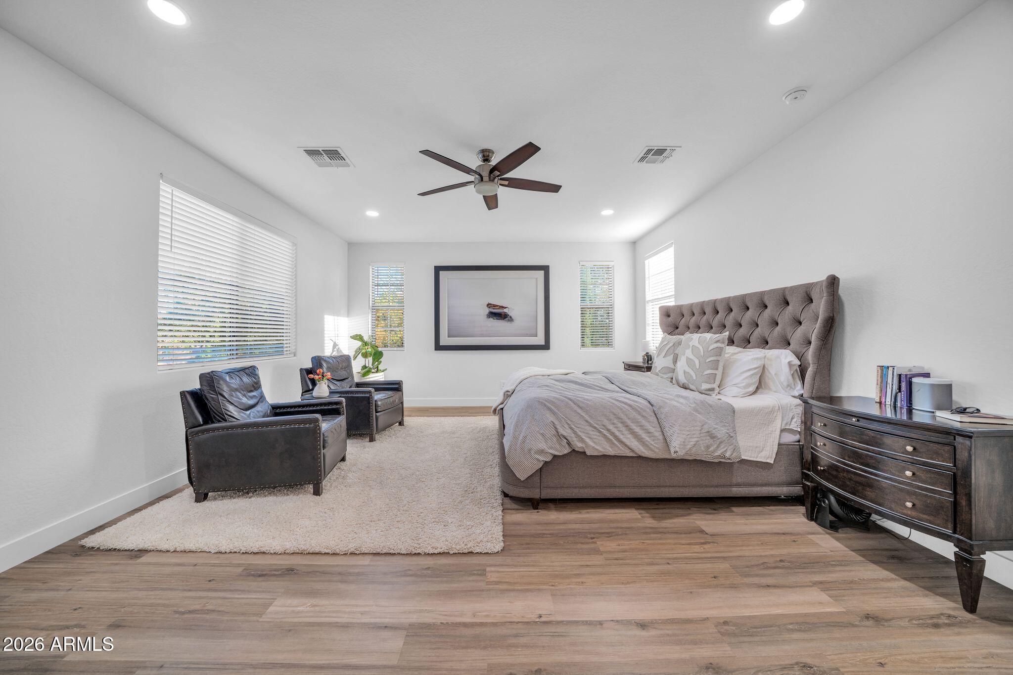 2985 North Point Ridge Road Buckeye, AZ 85396 - Photo 61 of 107 a spacious bedroom with a bed a couch and a chandelier
