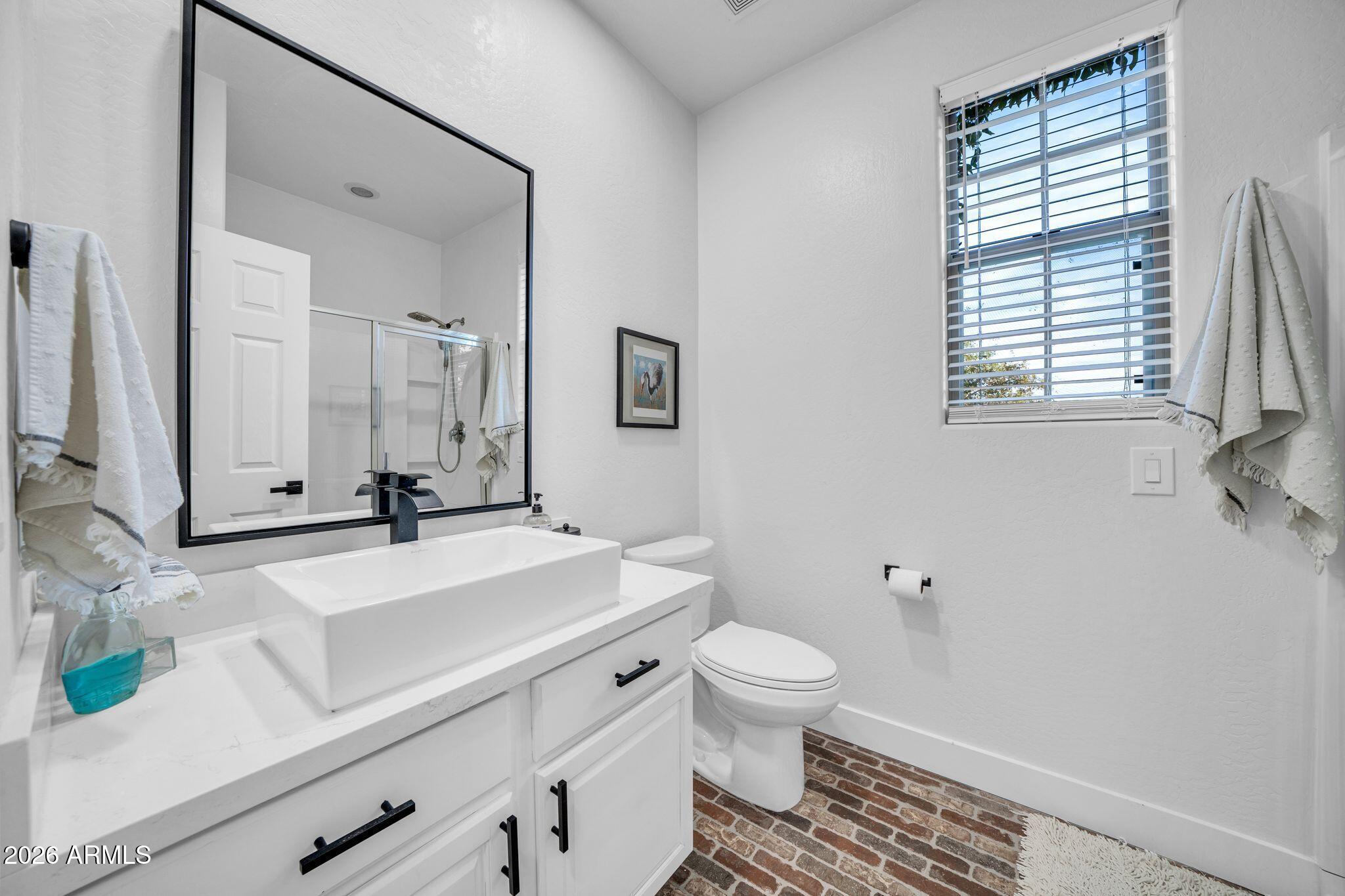 2985 North Point Ridge Road Buckeye, AZ 85396 - Photo 72 of 107 a bathroom with a sink toilet a mirror and window