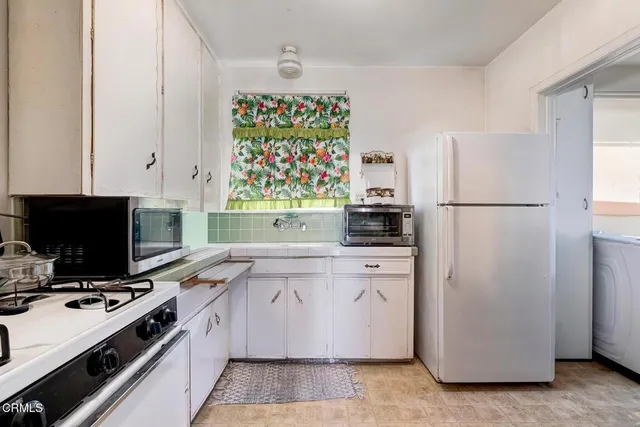 a view of a hallway with chairs and a refrigerator