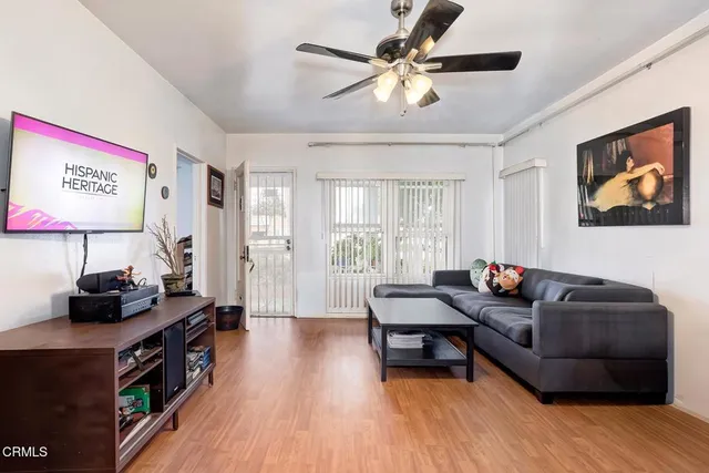 a living room with furniture and a wooden floor
