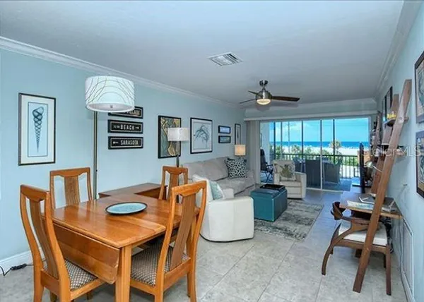 a dining room with furniture and a floor to ceiling window