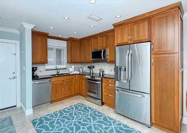 a kitchen with stainless steel appliances granite countertop a refrigerator stove top oven and sink