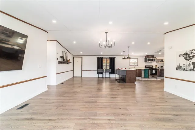a view of a livingroom with furniture a ceiling fan and wooden floor