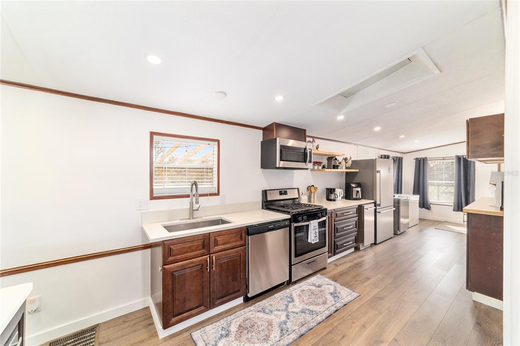 5150 Southeast 117th Avenue Morriston, FL 32668 - Photo 21 of 63 a kitchen with stainless steel appliances granite countertop a sink stove and wooden floor