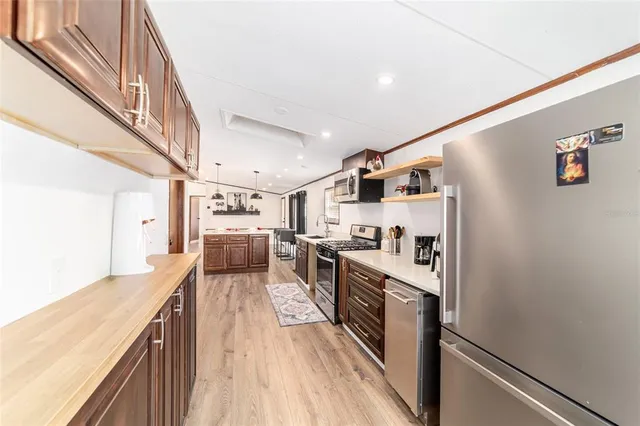 a kitchen with stainless steel appliances a refrigerator and wooden floor