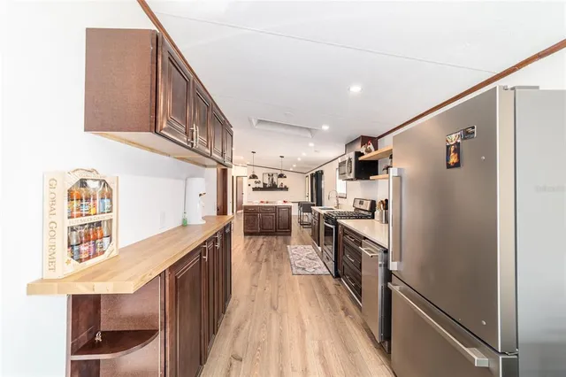 a kitchen with stainless steel appliances a sink a stove a refrigerator cabinets and a counter top space