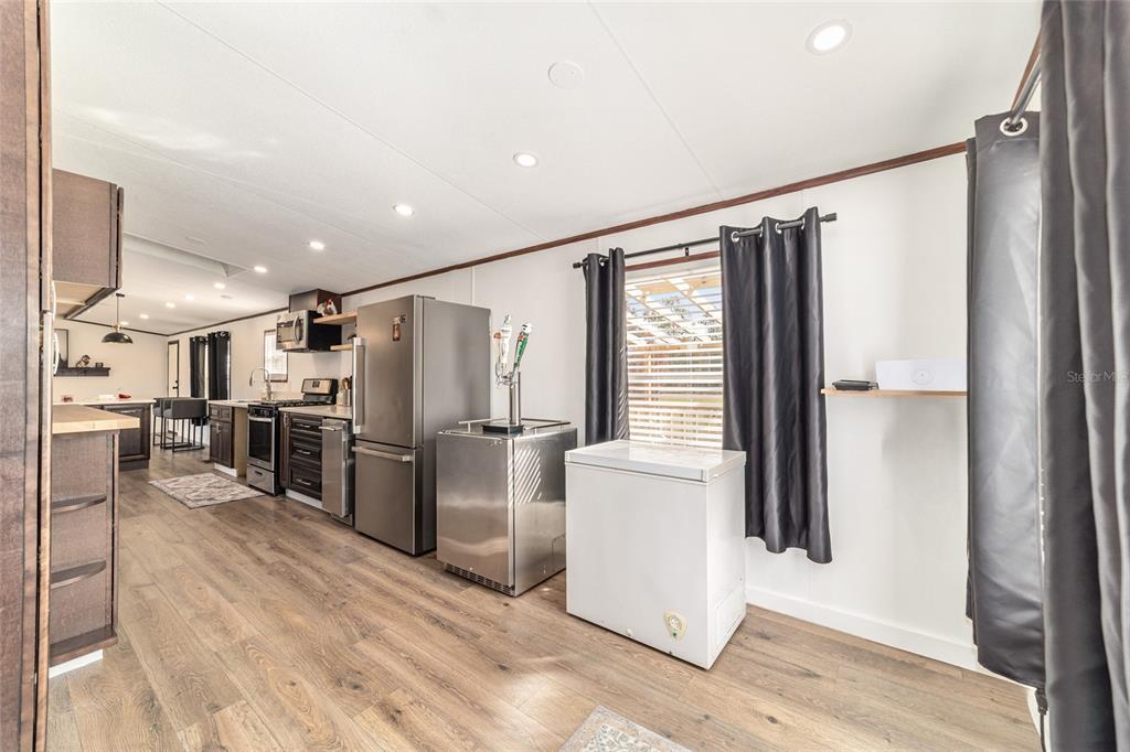 5150 Southeast 117th Avenue Morriston, FL 32668 - Photo 26 of 63 a kitchen with stainless steel appliances a refrigerator and wooden floor